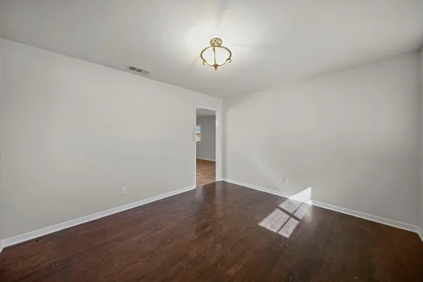 a view of a room with wooden floor and white walls