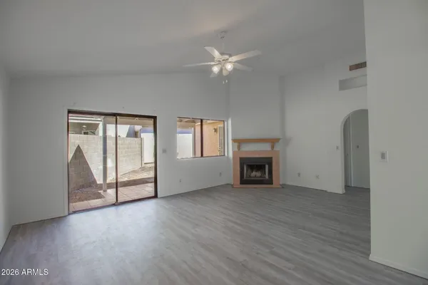 a view of a livingroom with wooden floor a fireplace and window
