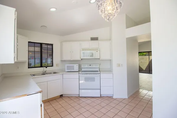 a kitchen with white cabinets and white appliances