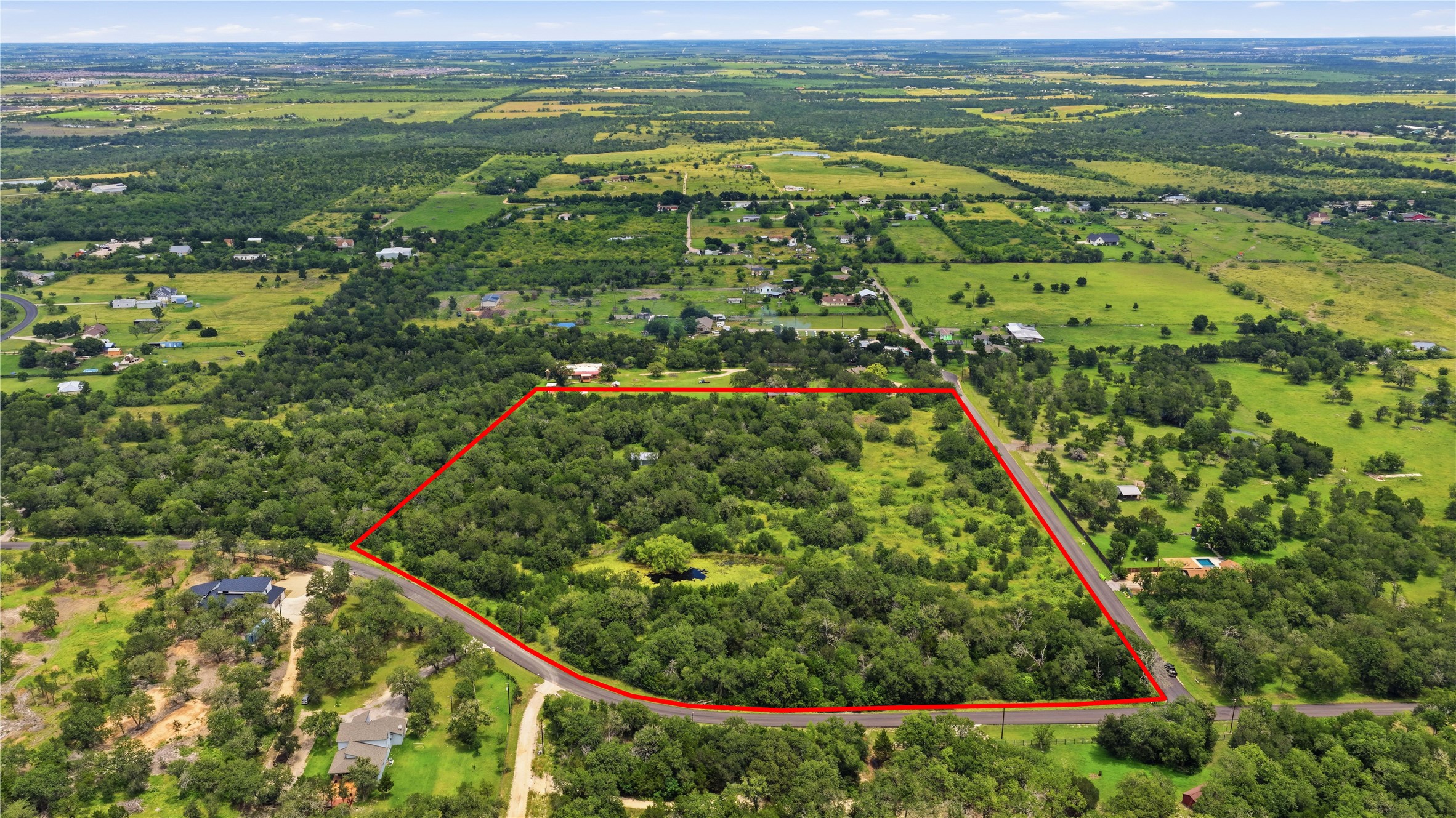 A vast expanse of natural terrain, offering a serene escape amidst mature trees and open fields.