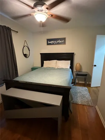 a bedroom with a bed and dresser with floor