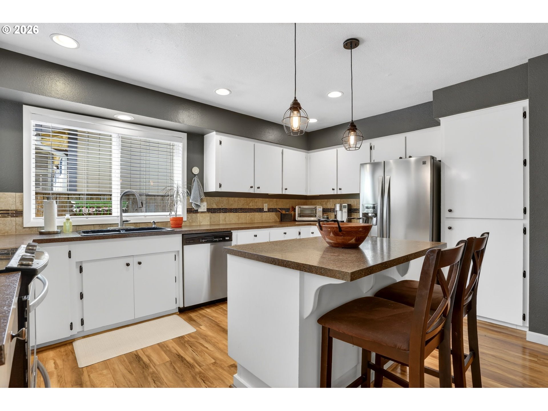 1776 Southeast 114th Place Portland, OR 97216 - Photo 14 of 47 a kitchen with stainless steel appliances a table chairs refrigerator and a sink
