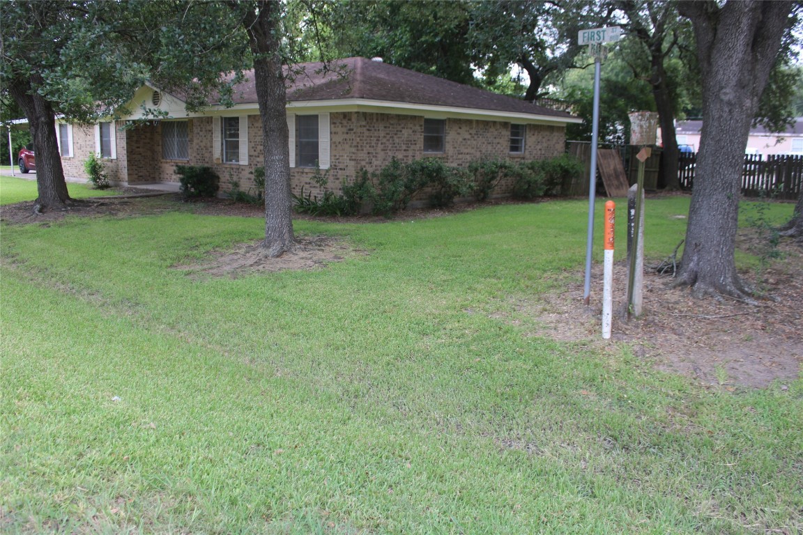 a view of a house with backyard and a tree