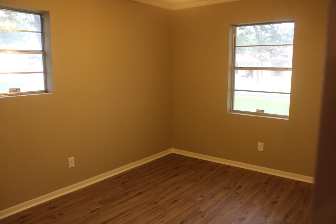708 1st Street Winnie, TX 77665 - Photo 28 of 35 an empty room with wooden floor and windows