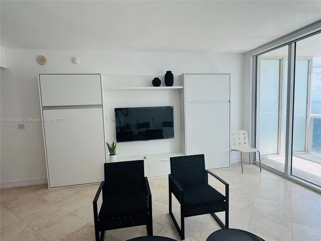 a view of a livingroom with furniture wooden floor and windows