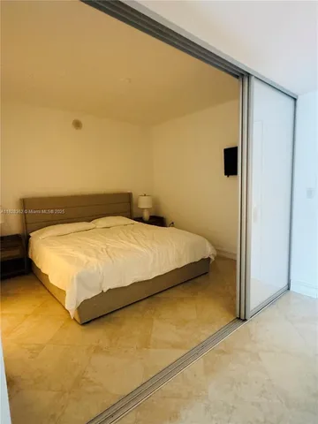 a bedroom with a bed and a lamp on desk