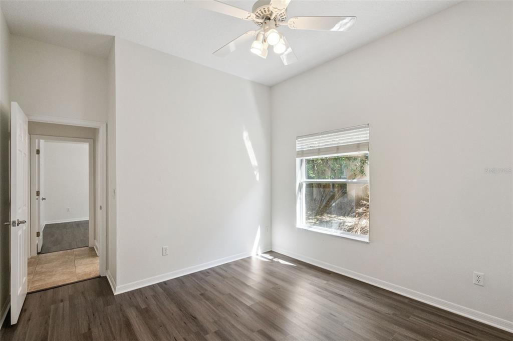 2541 Teton Stone Run Orlando, FL 32828 - Photo 38 of 82 an empty room with wooden floor chandelier fan and windows