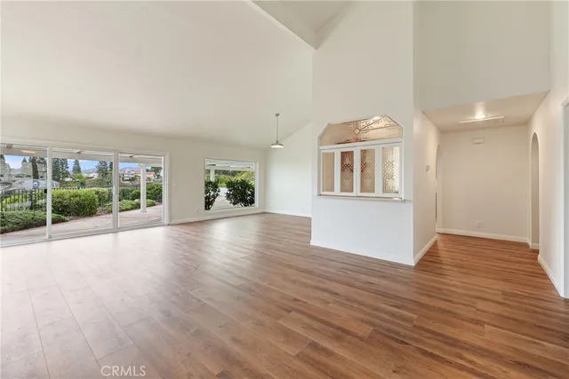 an empty room with windows and fireplace