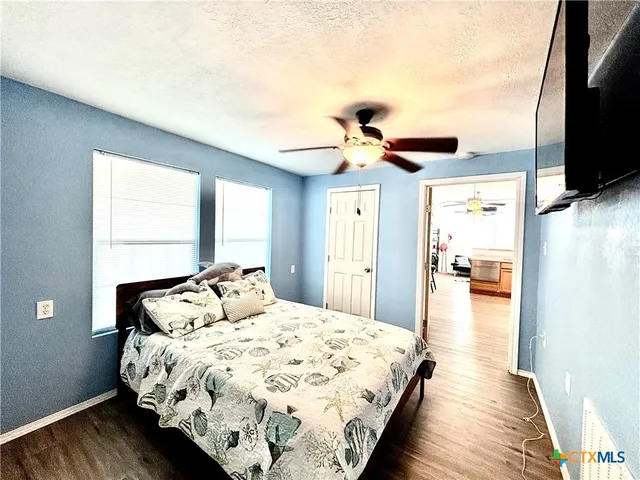 a bedroom with a bed and a flat tv screen on dresser
