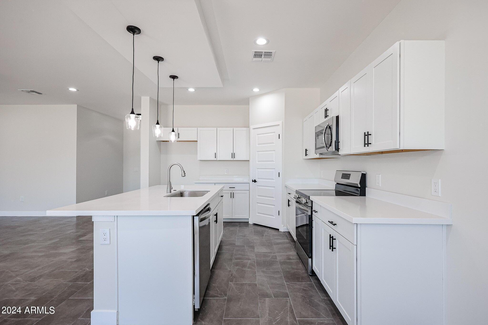 1028 South Wintersburg Road Tonopah, AZ 85354 - Photo 12 of 48 a kitchen with stainless steel appliances sink a stove top oven a white refrigerator a sink and dishwasher