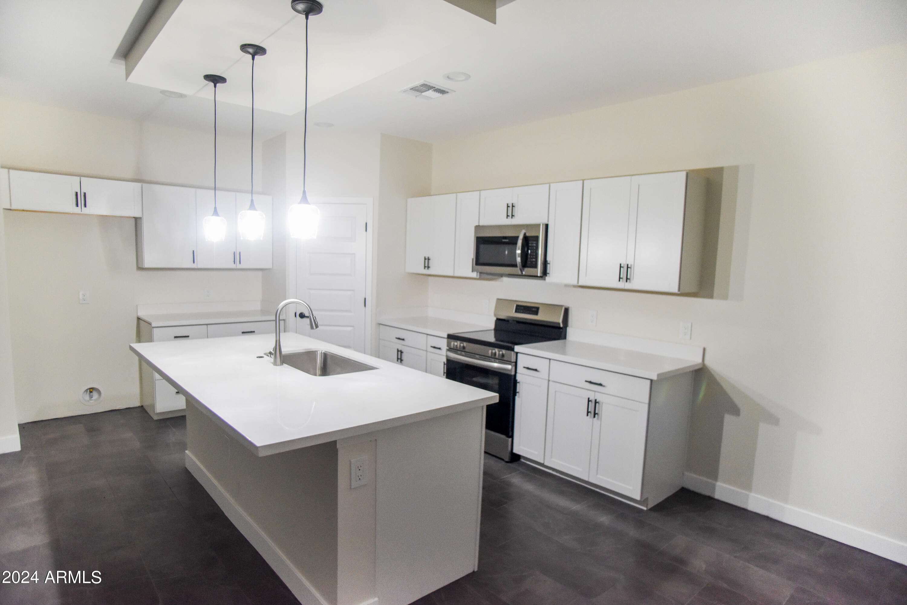 1028 South Wintersburg Road Tonopah, AZ 85354 - Photo 13 of 48 a kitchen with sink a microwave and cabinets