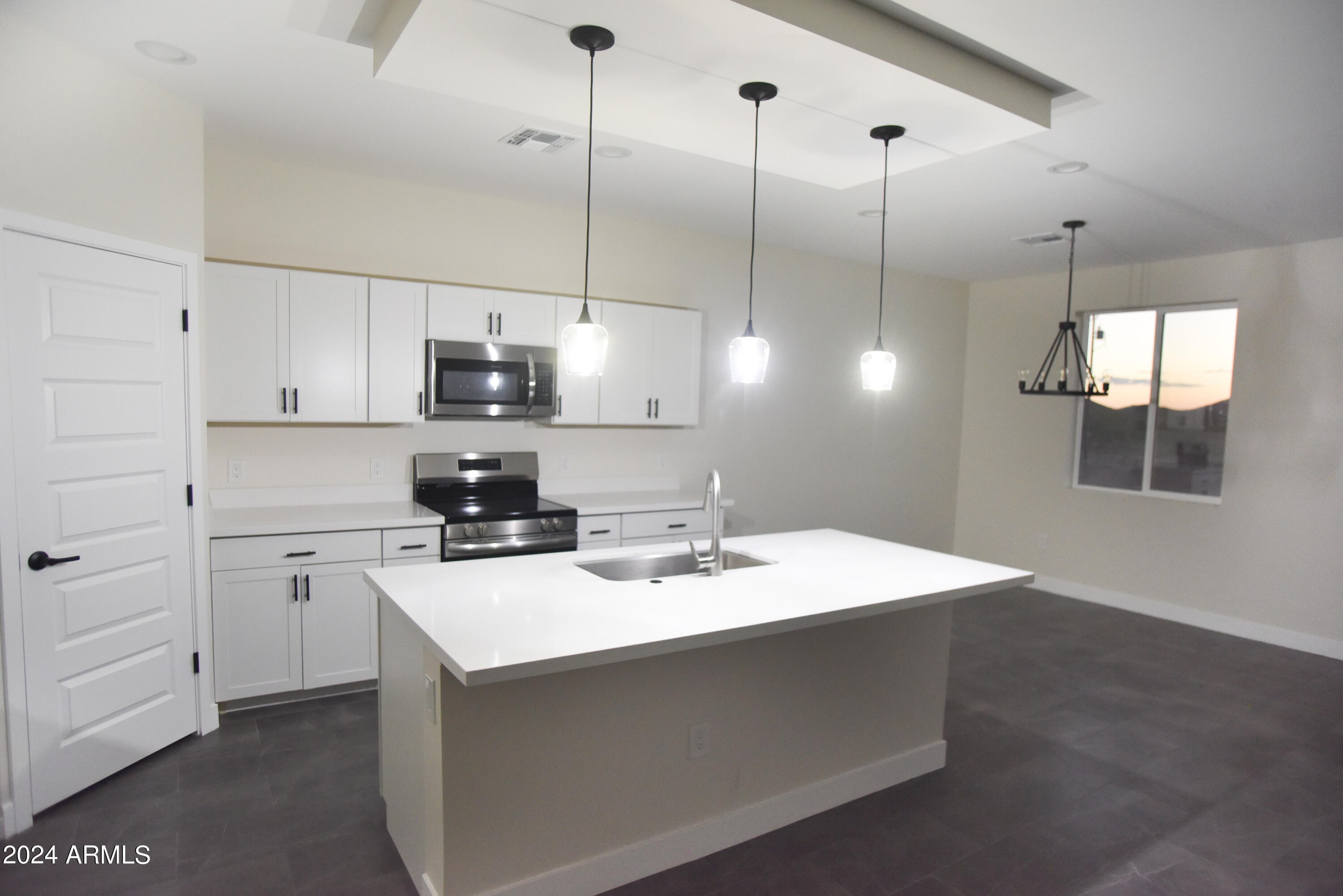 1028 South Wintersburg Road Tonopah, AZ 85354 - Photo 15 of 48 a kitchen with a sink a stove and cabinets