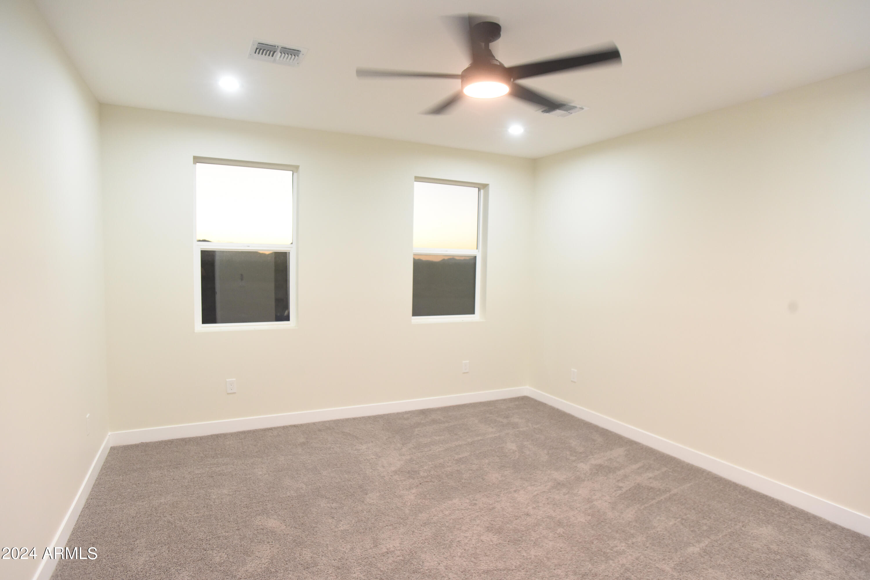 1028 South Wintersburg Road Tonopah, AZ 85354 - Photo 18 of 48 an empty room with a ceiling fan and a window