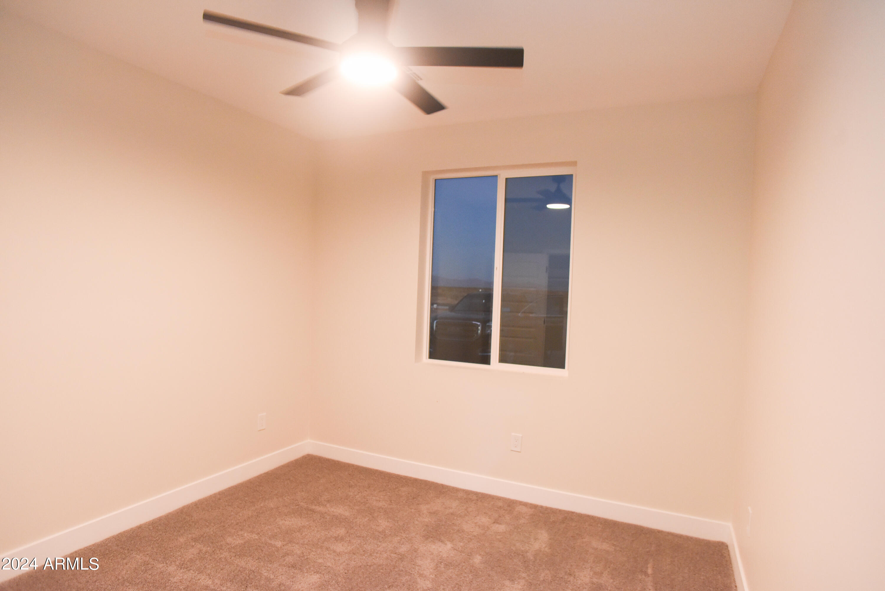 1028 South Wintersburg Road Tonopah, AZ 85354 - Photo 30 of 48 an empty room with ceiling fan and windows