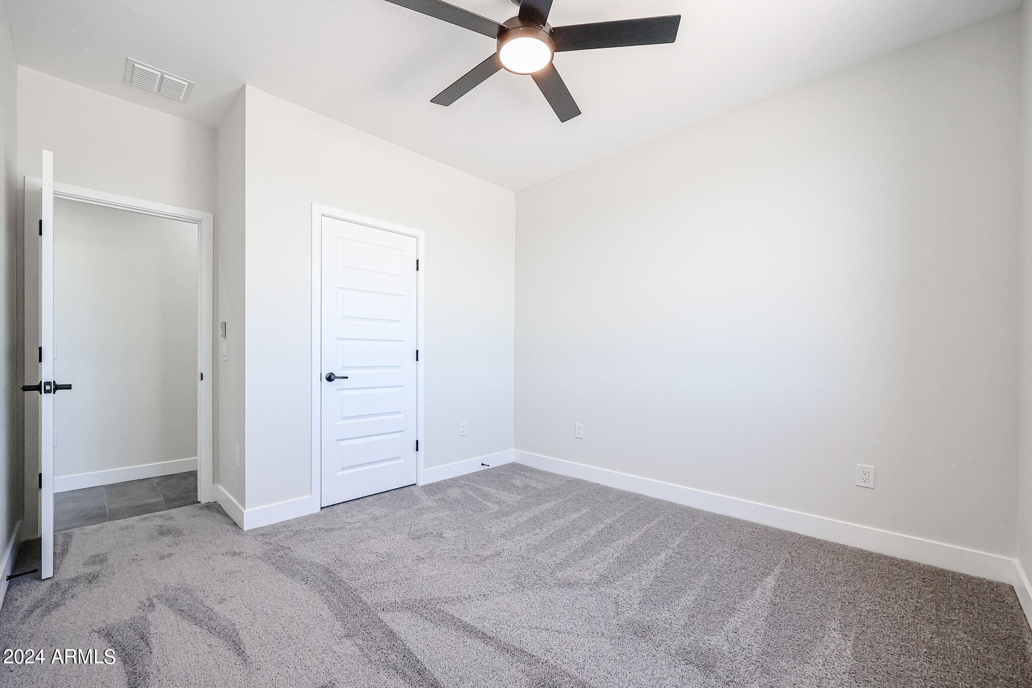 1028 South Wintersburg Road Tonopah, AZ 85354 - Photo 45 of 48 an empty room with closet and fan