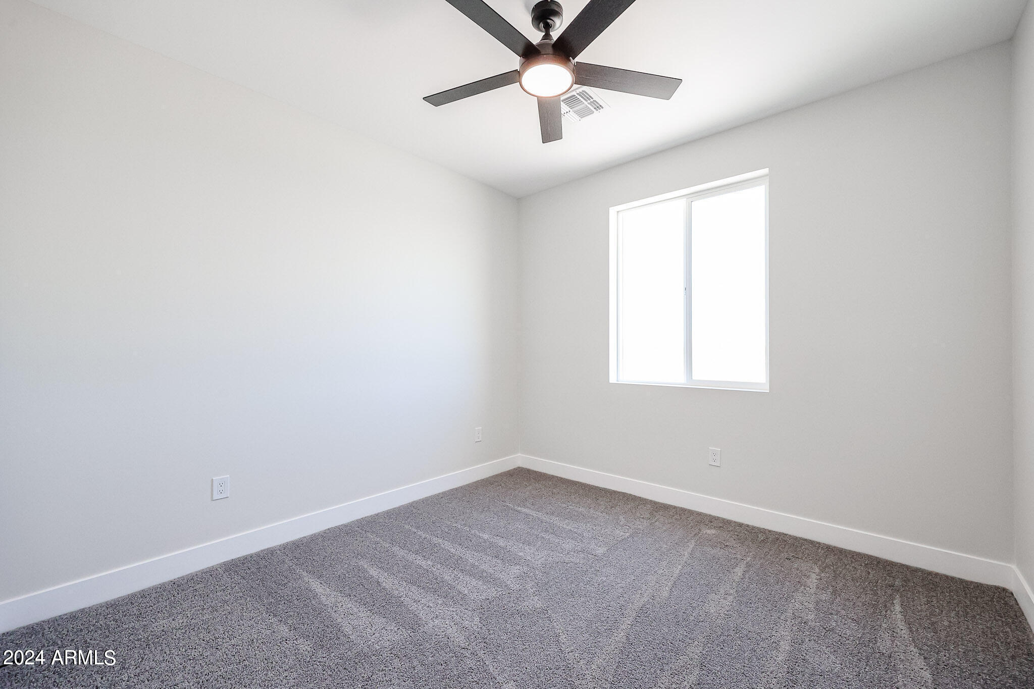 1028 South Wintersburg Road Tonopah, AZ 85354 - Photo 46 of 48 an empty room with a window and a fan