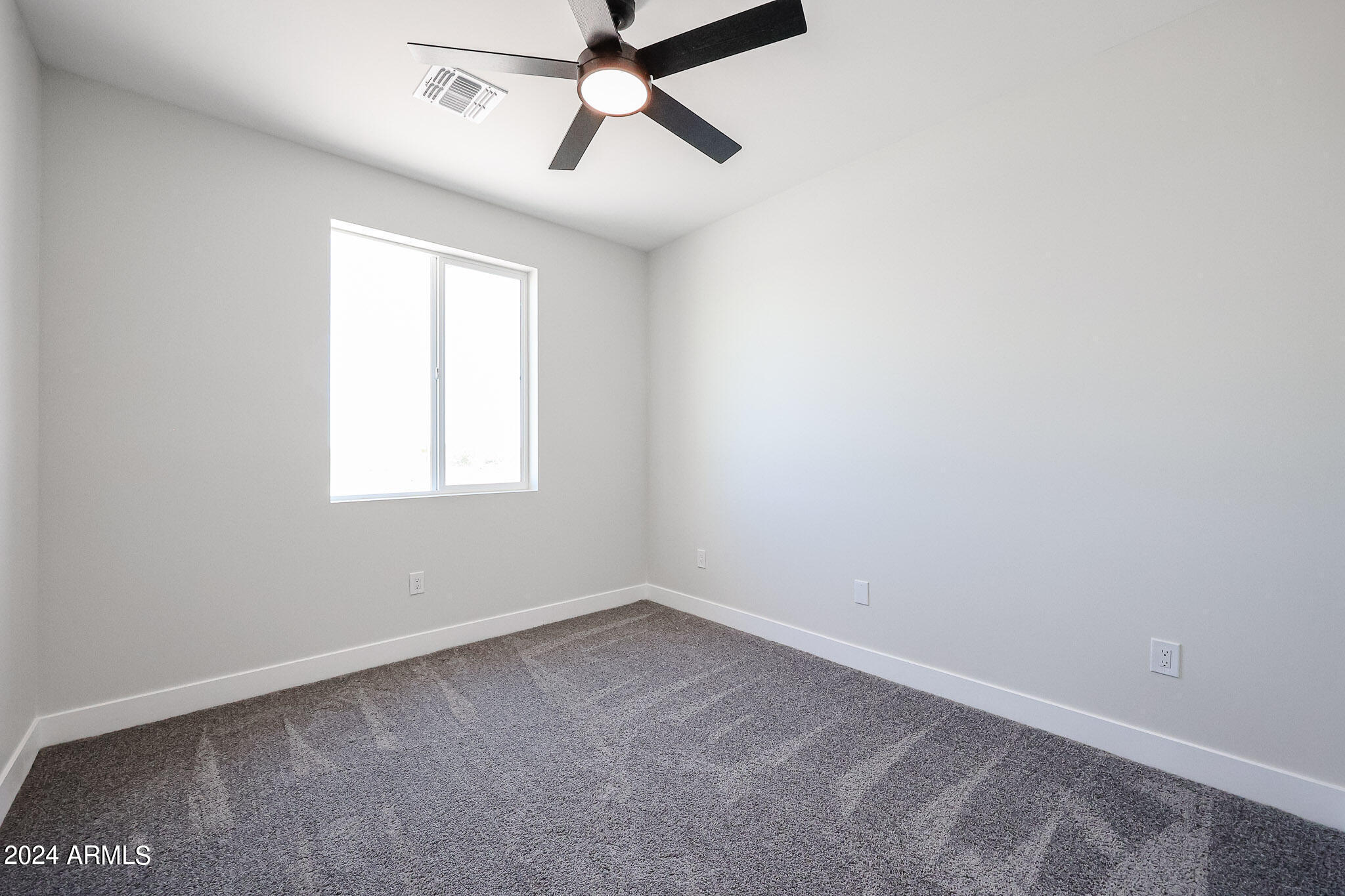 1028 South Wintersburg Road Tonopah, AZ 85354 - Photo 47 of 48 an empty room with a window and a fan