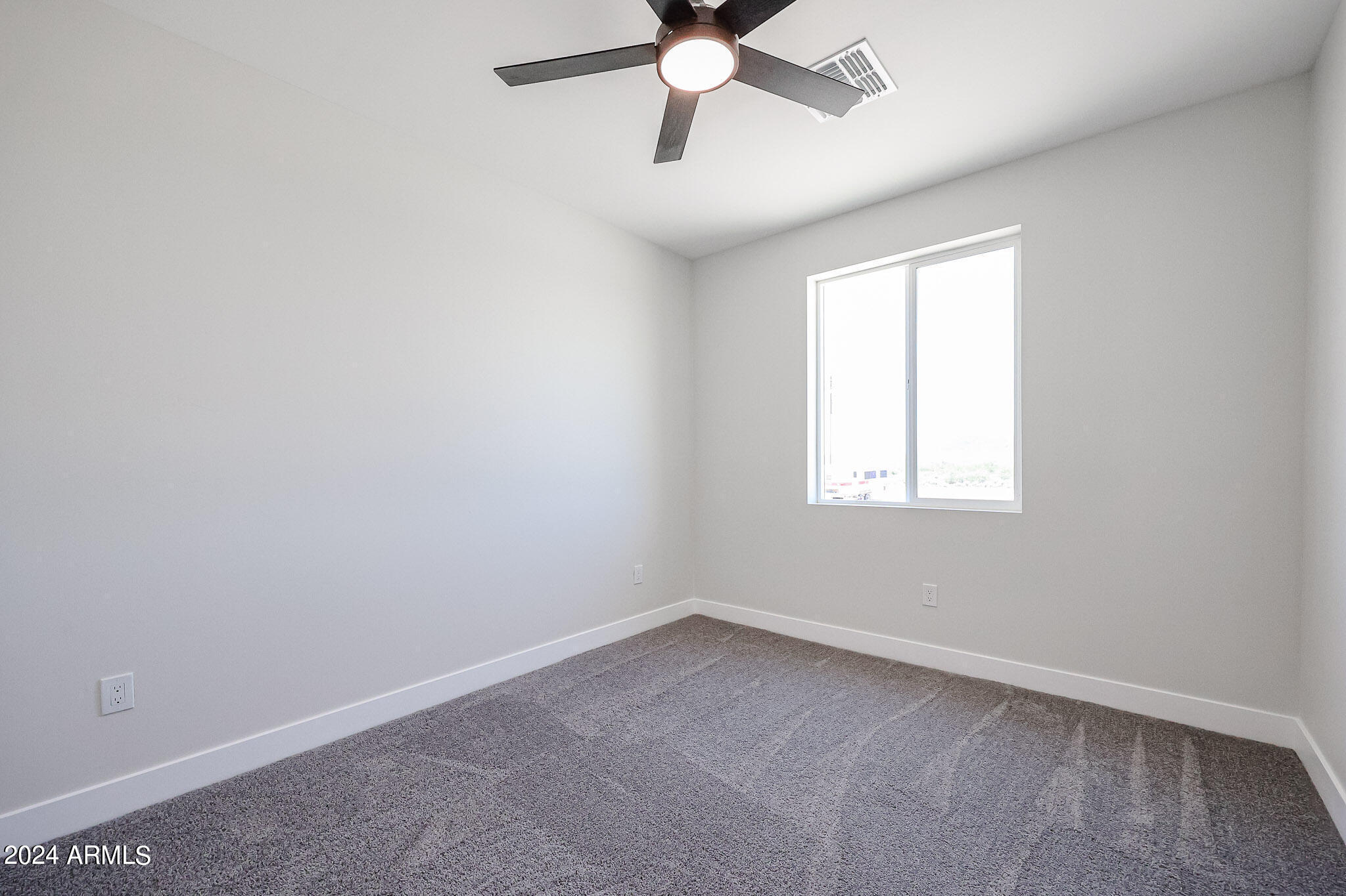 1028 South Wintersburg Road Tonopah, AZ 85354 - Photo 48 of 48 an empty room with a window and a fan