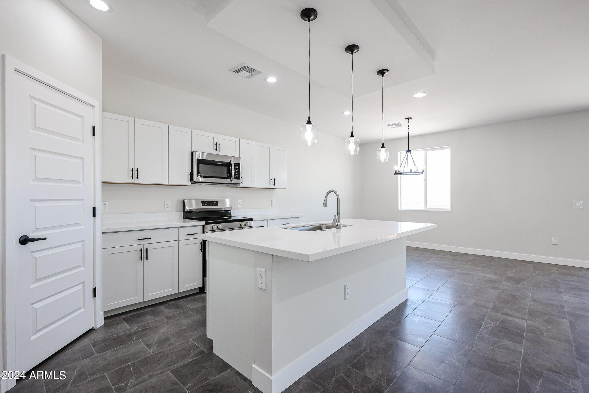 1028 South Wintersburg Road Tonopah, AZ 85354 - Photo 10 of 48 a kitchen with kitchen island granite countertop appliances cabinets and a sink