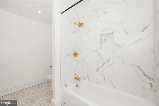 a bathroom with a granite countertop sink mirror vanity and toilet