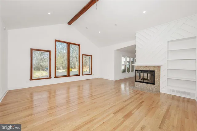 an empty room with wooden floor and mirror