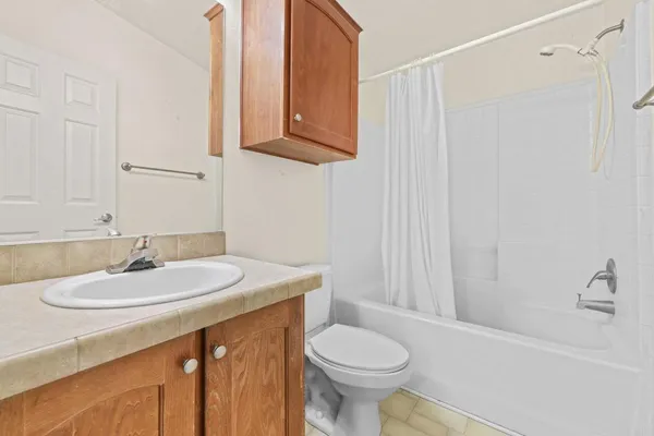 a view of an empty room with window and a kitchen