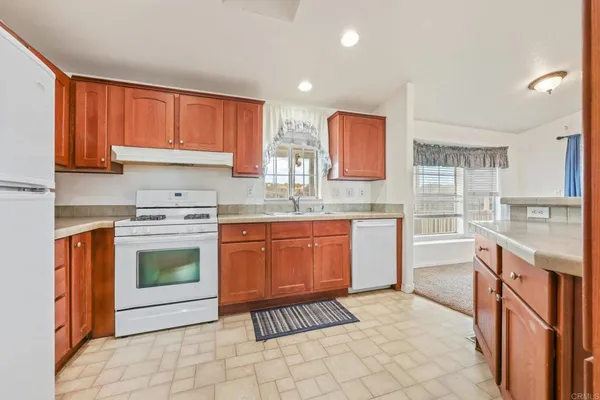 a view of a livingroom with a fireplace a ceiling fan and window