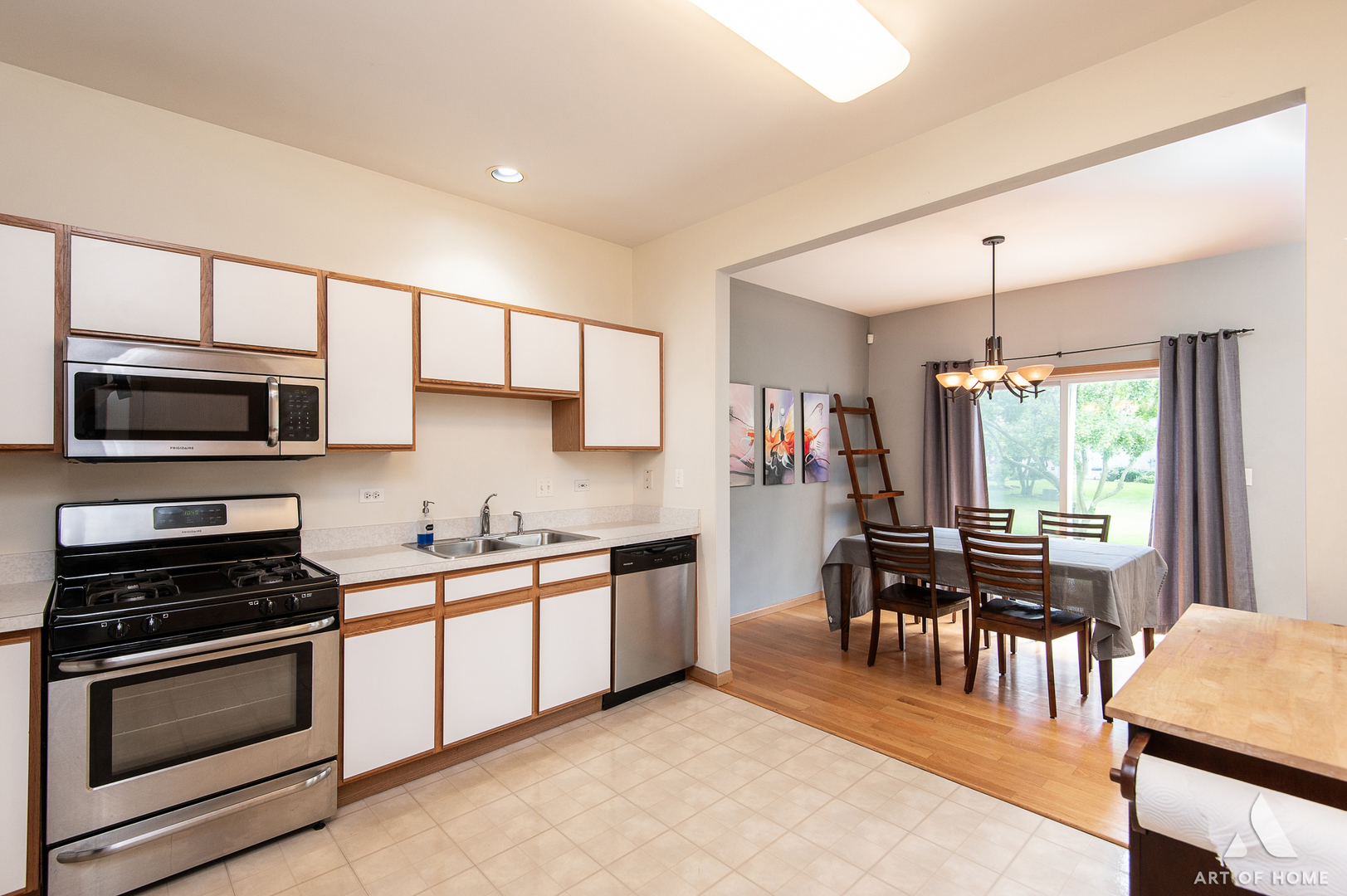 397 Littleton Trail Elgin, IL 60120 - Photo 12 of 30 a kitchen with stainless steel appliances granite countertop a stove top oven a sink dishwasher a dining table and chairs with wooden floor
