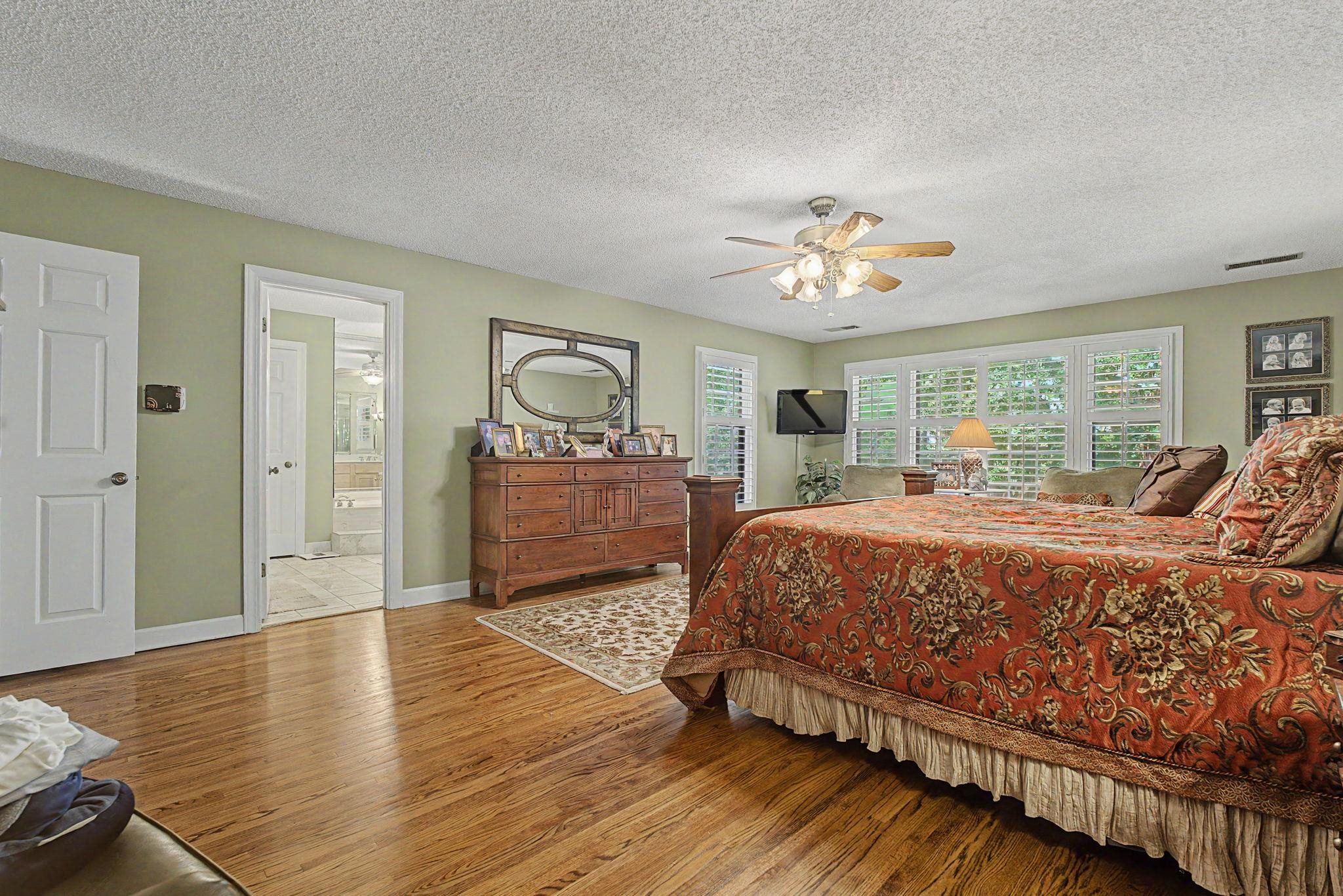 1929 Miller Farms Road Germantown, TN 38138 - Photo 20 of 40 Spacious bedroom featuring wood-finish flooring, a ceiling fan, and multiple windows with plantation shutters