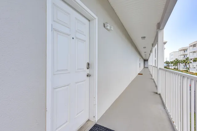 a view of a hallway with white walls and stairs