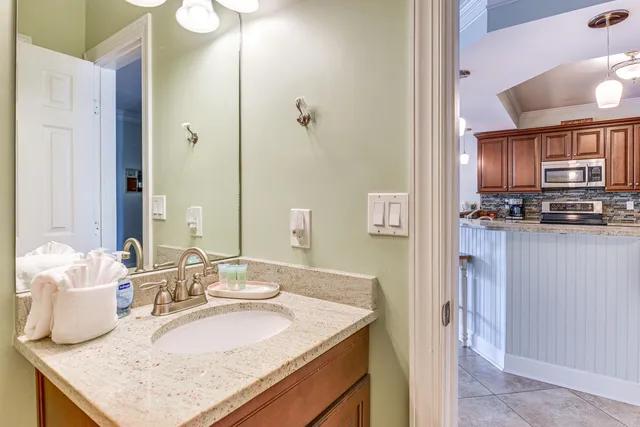 a bathroom with a granite countertop sink and a mirror