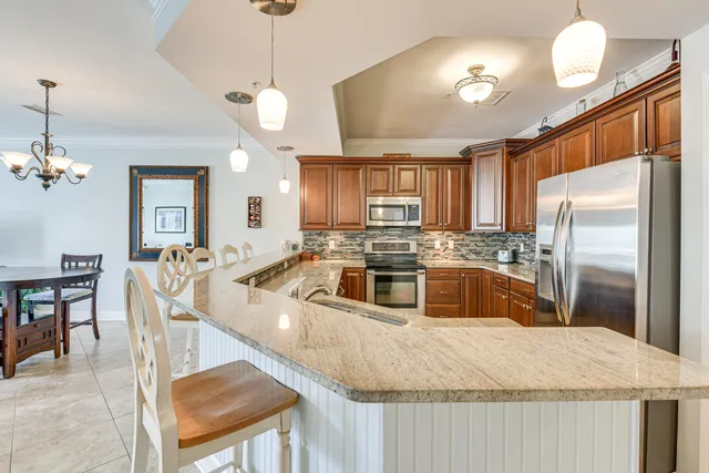 a kitchen with stainless steel appliances granite countertop a sink a stove and a refrigerator