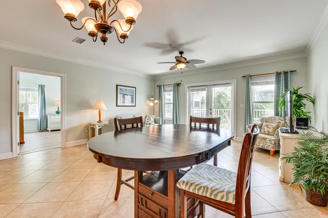 a view of a dining room and livingroom with furniture wooden floor a chandelier