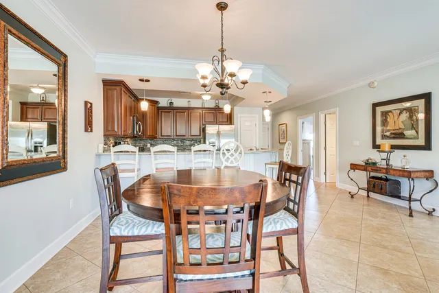 a dining room with wooden floor a chandelier a wooden table and chairs