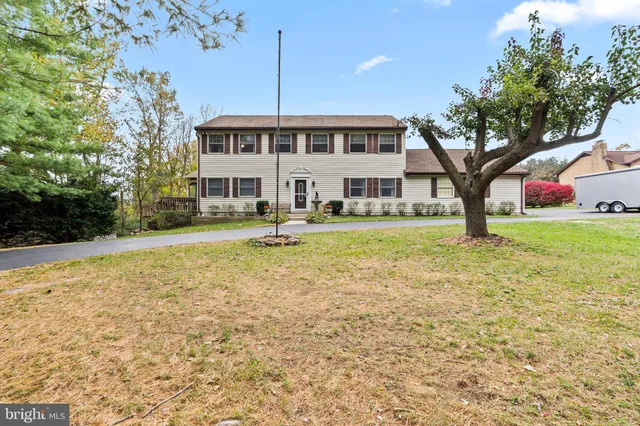 a front view of a house with a yard and trees