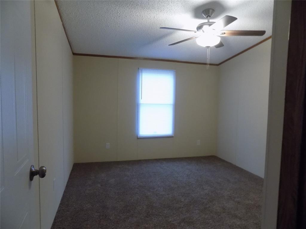 3450 Sarra Lane Springtown, TX 76082 - Photo 15 of 23 Carpeted secondary bedroom with good window light and ceiling fan.