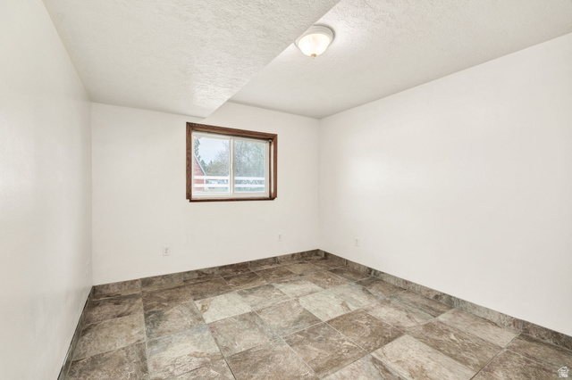 365 South Center Street Fielding, UT 84311 - Photo 26 of 41 Unfurnished room with stone finish floors and a textured ceiling