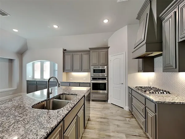 a kitchen with stainless steel appliances a refrigerator and a stove top oven