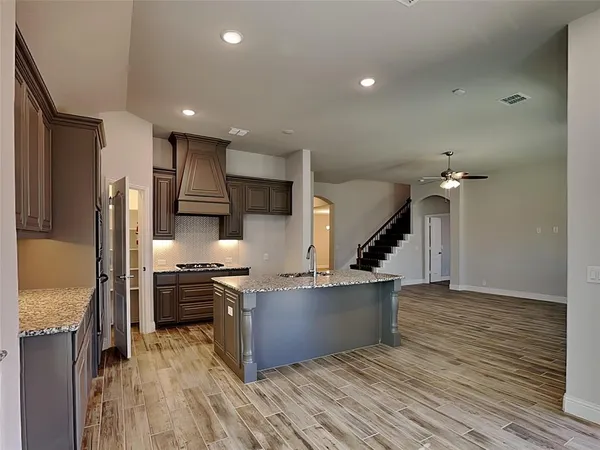 a view of a room with wooden floor and ceiling fan