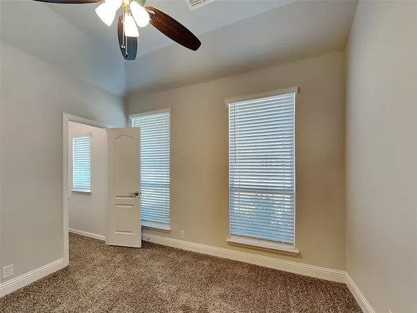 an empty room with a ceiling fan and a window