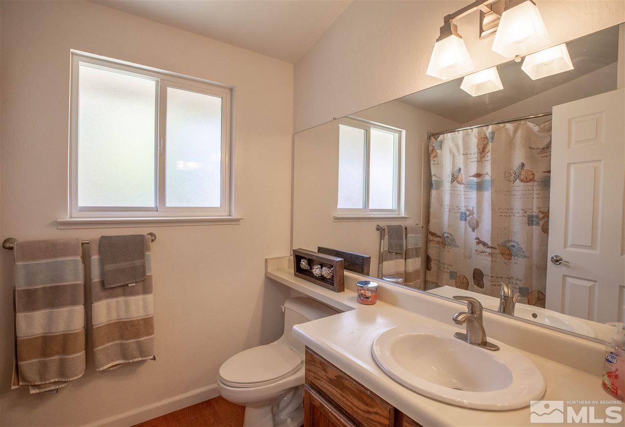 1114 Indian Cove Way Reno, NV 89523 - Photo 16 of 17 a bathroom with a sink a toilet and a mirror