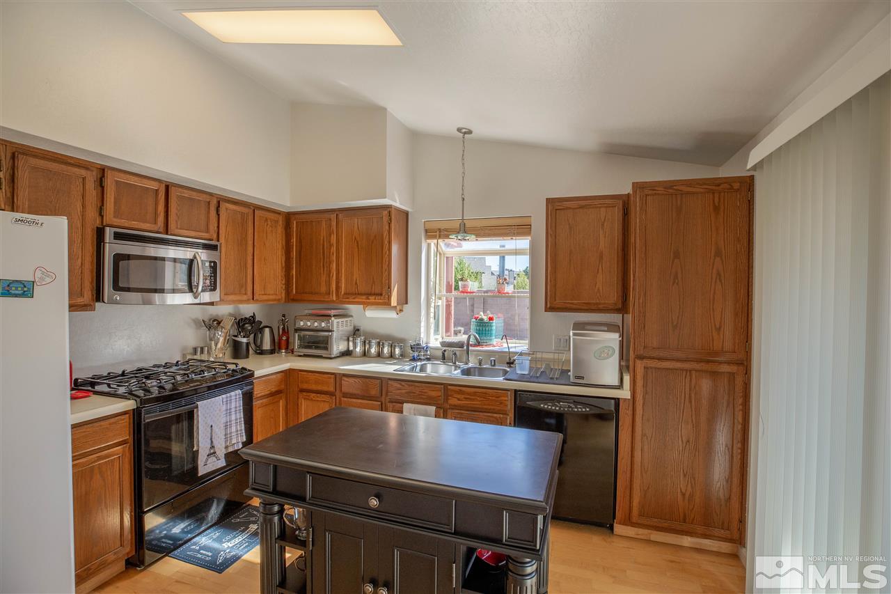 1114 Indian Cove Way Reno, NV 89523 - Photo 8 of 17 a kitchen with stainless steel appliances a sink cabinets and wooden floor