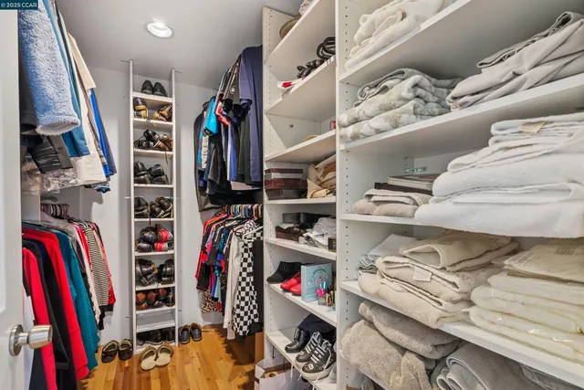 a view of walk in closet with clothes and shoes