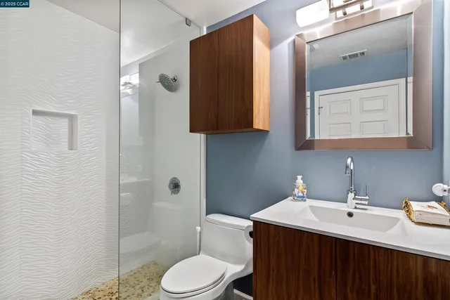 a bathroom with a sink a toilet and shower