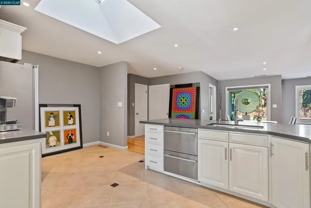 a kitchen with white cabinets and sink