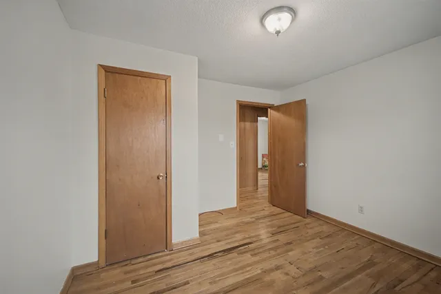 an empty room with wooden floor and closet