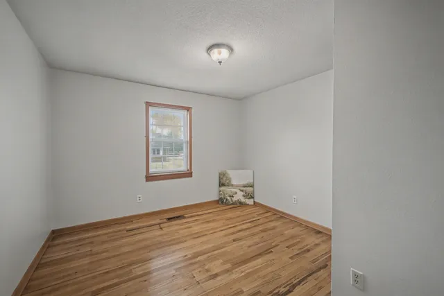 a room with a bed and wooden floor