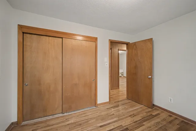 an empty room with closet and wooden floor