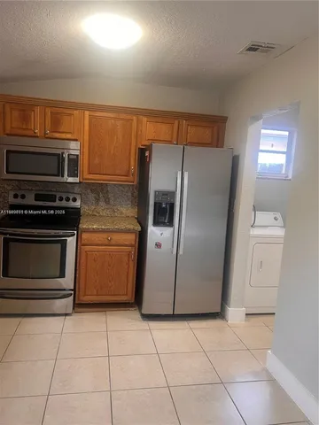 a kitchen with a stove a microwave and a refrigerator