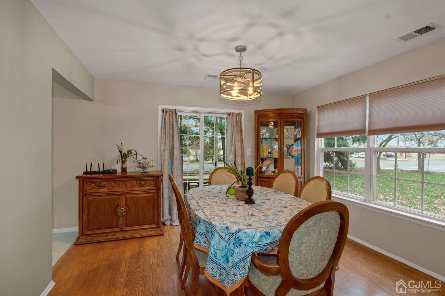 58 Nova Drive Piscataway, NJ 08854 - Photo 5 of 16 a dining room with wooden floor and a chandelier